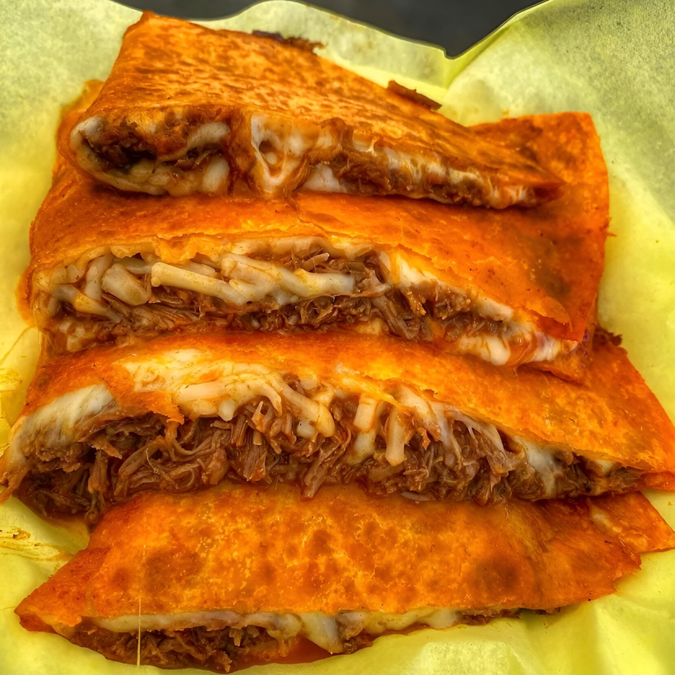 Four birria quesadillas with melted cheese and shredded meat, served on yellow paper.